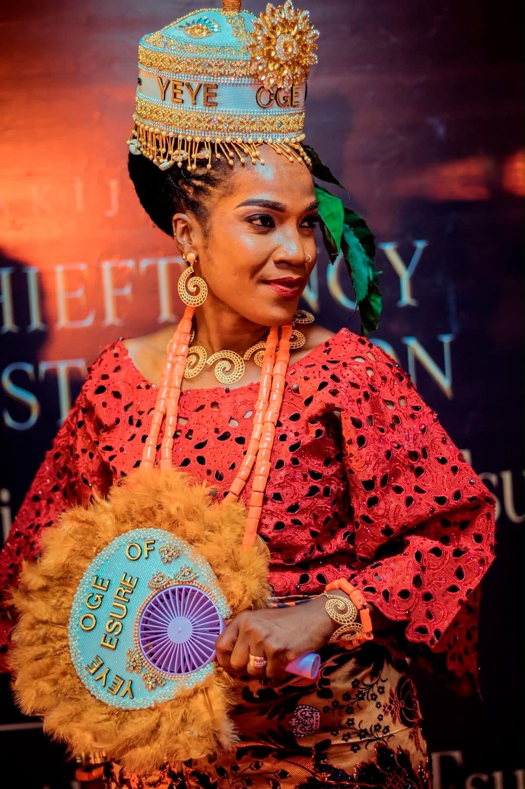 A ceremonial moment during the investiture, guests in red traditional dress.